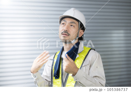 工事現場で働く作業員 作業着姿で汗をかく男性　熱中症予防もご安全に 105386737