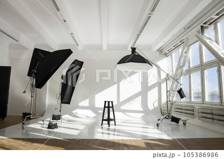 White big huge cyclorama in modern professional photo studio with a professional equipment, ligts, stands and soft boxes. White big huge cyclorama in modern professional photo studio with a professional equipment, ligts, stands and soft boxes. 105386986