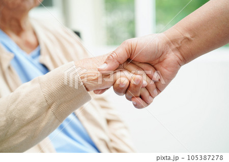 Doctor holding hands Asian elderly woman patient, help and care in hospital. Doctor holding hands Asian elderly woman patient, help and care in hospital. 105387278