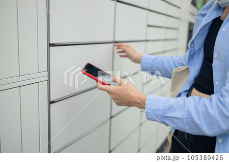 Woman client using automated self service post terminal machine or locker. Mail shipping concept Woman client using automated self service post terminal machine or locker. Mail shipping concept 105389426