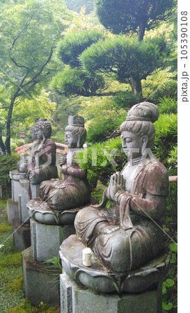 小雨に煙る清林寺の庭にある仏像 105390108