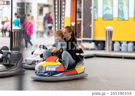Angry mom scolds her son sitting in the dodgem Angry mom scolds her son sitting in the dodgem 105390358