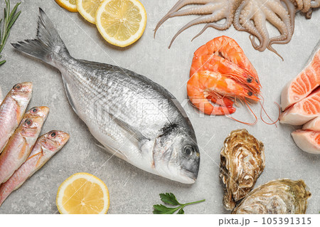 Fresh fish and seafood on light grey table, flat lay 105391315
