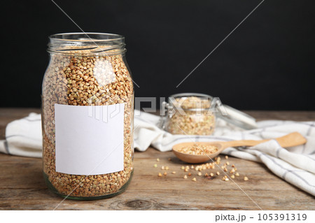 Organic green buckwheat in jar with blank label on wooden table Organic green buckwheat in jar with blank label on wooden table 105391319