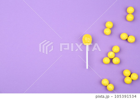 Different lemon candies on purple background, top view. Space for text 105391534