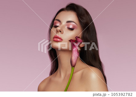 Beautiful young woman with a calla flower Beautiful young woman with a calla flower 105392782