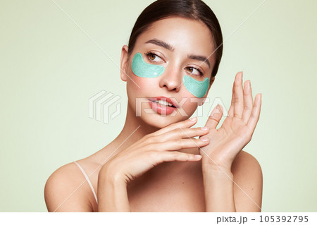 Young woman with cosmetic patches on her eyes Young woman with cosmetic patches on her eyes 105392795