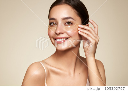 Young woman with cosmetic patches on her eyes Young woman with cosmetic patches on her eyes 105392797