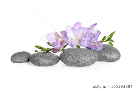 Spa stones and freesia flowers on white background Spa stones and freesia flowers on white background 105393884