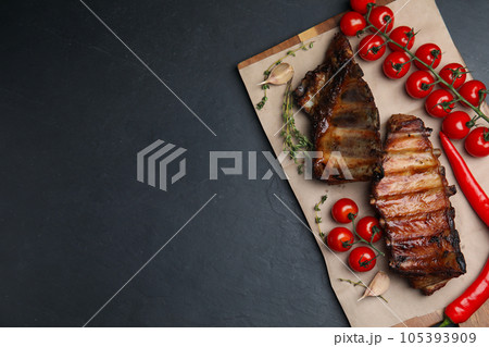 Tasty grilled ribs on black table, flat lay. Space for text Tasty grilled ribs on black table, flat lay. Space for text 105393909