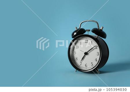 Alarm clock on light blue background, space for text. Morning time 105394030