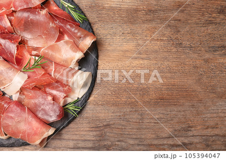 Pile of tasty prosciutto on wooden table, top view. Space for text Pile of tasty prosciutto on wooden table, top view. Space for text 105394047