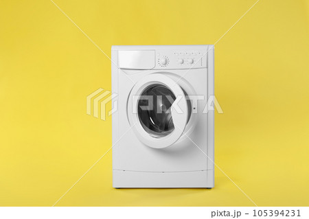 Modern washing machine on yellow background. Laundry day Modern washing machine on yellow background. Laundry day 105394231