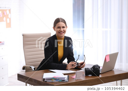 Young journalist working at table in office Young journalist working at table in office 105394402