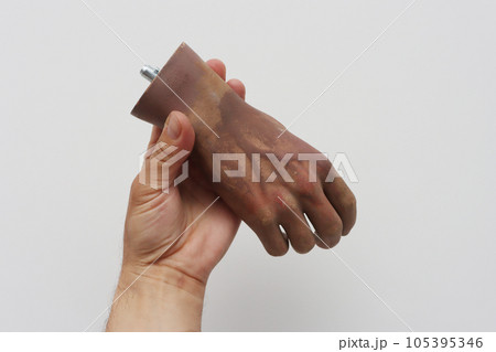 A real human hand holding an artificial plastic hand. A real human hand holding an artificial plastic hand. 105395346