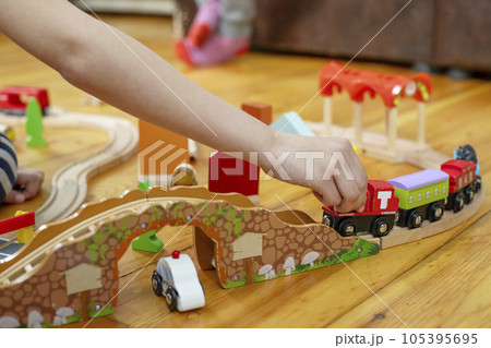 Child is playing with toy railway road at home or in kindergarten on the floor 105395695