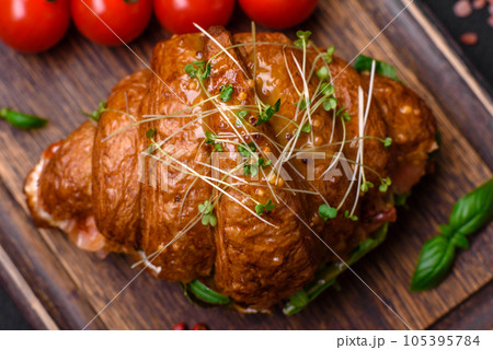 Delicious crispy croissant with salmon, lettuce, cheese and tomatoes 105395784