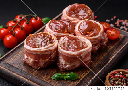 Delicious raw fresh pork or chicken meat rolls wrapped in bacon 105395792