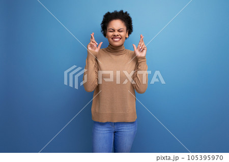 positive young bright latino woman with afro hair gathered in a ponytail against the background with positive young bright latino woman with afro hair gathered in a ponytail against the background with 105395970