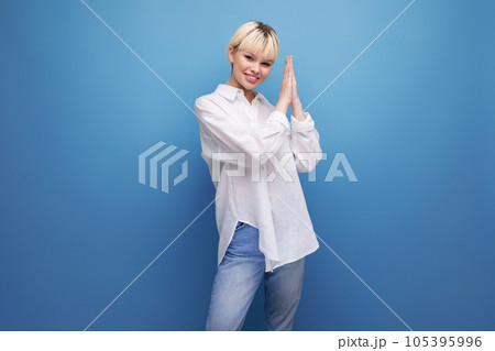 young successful blond career woman in a white shirt on a blue background with copy space. career 105395996