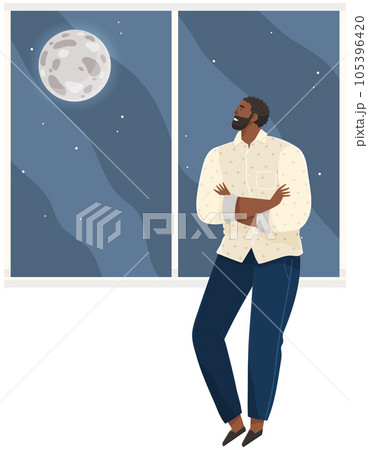 Young smiling man thinking about something and looks out window at moon and dark sky with stars 105396420