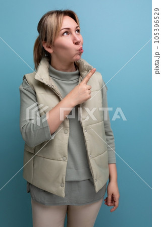 young blond woman pointing finger at stock offer on wall young blond woman pointing finger at stock offer on wall 105396529