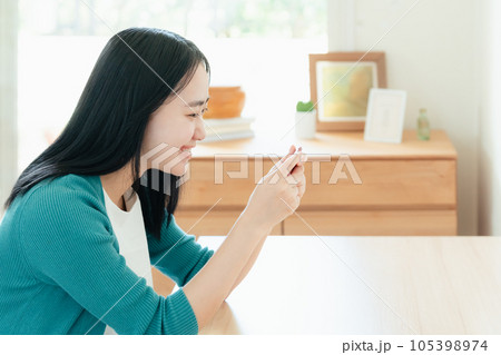 スマートフォンで動画視聴する若い女性 スマートフォンで動画視聴する若い女性 105398974