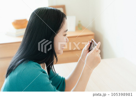 スマートフォンで動画視聴する若い女性 スマートフォンで動画視聴する若い女性 105398981