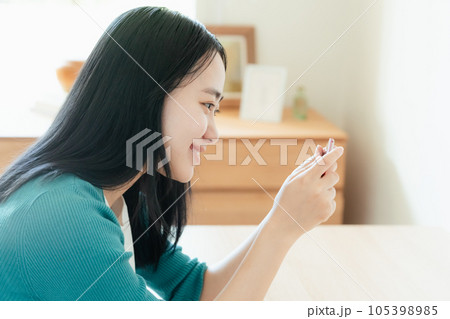 スマートフォンで動画視聴する若い女性 スマートフォンで動画視聴する若い女性 105398985