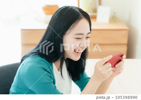 スマートフォンで動画視聴する若い女性 スマートフォンで動画視聴する若い女性 105398990