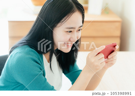 スマートフォンで動画視聴する若い女性 スマートフォンで動画視聴する若い女性 105398991