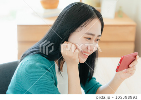 スマートフォンで動画視聴する若い女性 スマートフォンで動画視聴する若い女性 105398993