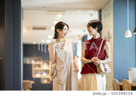 笑顔で話をしながら歩く2人のアラサーの女性 笑顔で話をしながら歩く2人のアラサーの女性 105399254