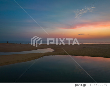 aerial panorama view reflection of scenery romantic sky of sunset at Karon beach. reflection amazing sky of sunset in the swamp next to the beach. colorful sky background. amazing sunset over sea  105399929