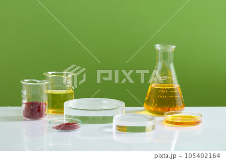 Set of empty round podiums decorated with some glassware containing yellow fluid. The antioxidants in saffron could help protect the brain from damage 105402164