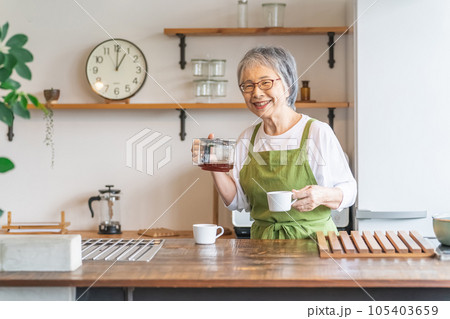 家・カフェのキッチンでコーヒーを淹れるアジア人高齢者女性 家・カフェのキッチンでコーヒーを淹れるアジア人高齢者女性 105403659