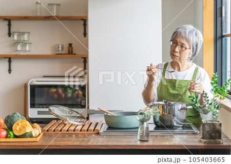 家のキッチンで料理を作るアジア人のシニア・高齢者女性（認知症・悩む） 105403665