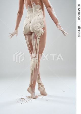 Nude body of woman in gypsum standing toe to toe 105403916