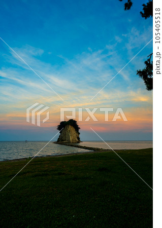 爽やかな青とオレンジに染まる幻想的な空と能登の観光名所見附島の夕景（別名軍艦島）｜石川県珠洲市 105405518