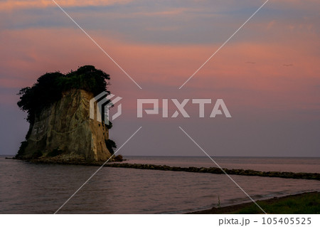 薄暮のオレンジに染まる幻想的な空と能登の観光名所見附島の夕景（別名軍艦島）｜石川県珠洲市 105405525