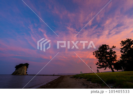 きれいな赤紫色に染まる幻想的な空と能登の観光名所見附島の夕景(別名軍艦島)|石川県珠洲市 きれいな赤紫色に染まる幻想的な空と能登の観光名所見附島の夕景(別名軍艦島)|石川県珠洲市 105405533