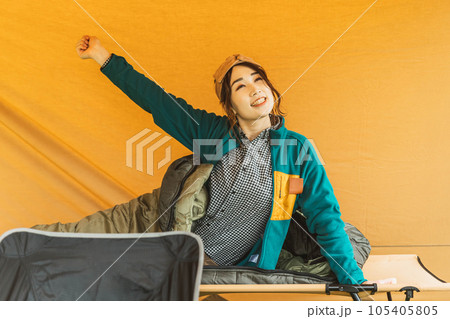 キャンプ場で寝袋・シュラフで寝る若い女性キャンパー（起床） 105405805