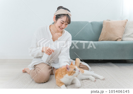 猫の体を除菌・消臭する飼い主の女性 猫の体を除菌・消臭する飼い主の女性 105406145