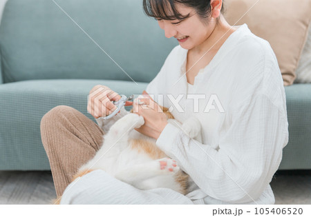 猫の爪切りをする飼い主のアジア人女性 105406520
