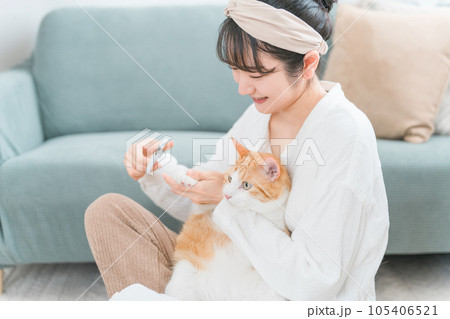 猫の爪切りをする飼い主のアジア人女性 猫の爪切りをする飼い主のアジア人女性 105406521