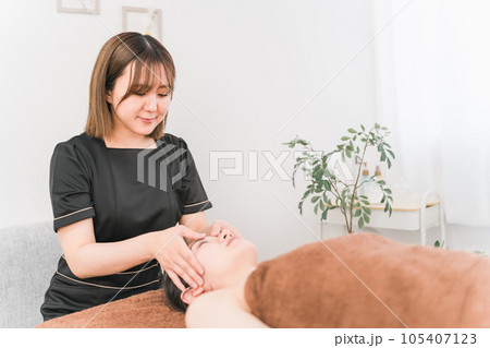 フェイシャルエステをするエステティシャンのアジア人女性(おでこ) フェイシャルエステをするエステティシャンのアジア人女性(おでこ) 105407123