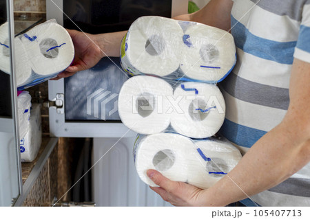 A man stocking up toilet paper at home. Crisis product lack concept 105407713