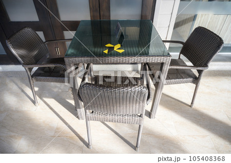 The marking on empty wooden table without nobody. Keep spaced between each chairs make separate for social distancing to avoid spreading of Covid-19. Social distance concept. The marking on empty wooden table without nobody. Keep spaced between each chairs make separate for social distancing to avoid spreading of Covid-19. Social distance concept. 105408368
