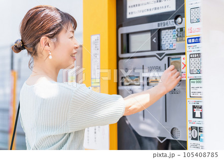 コインパーキング・駐車場のお金を入れる女性 105408785