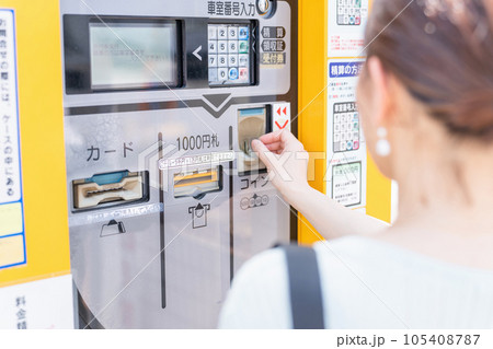コインパーキング・駐車場のお金を入れる女性 105408787